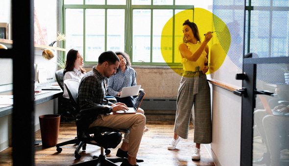 A woman presenting to a group at a whiteboard