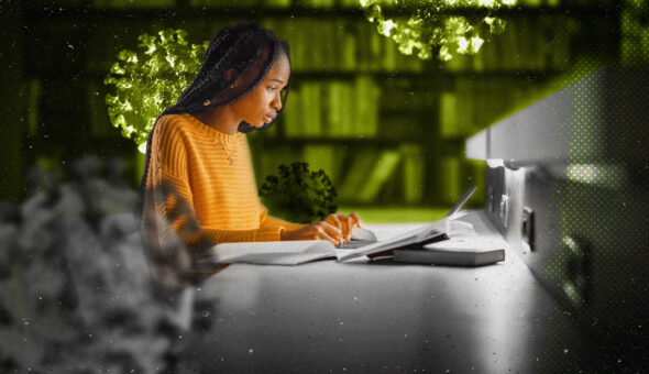 Woman with brown skin and black braids wearing a yellow shirt on a laptop.