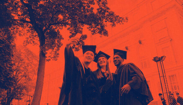 Image of three college students in cap and gown taking a selfie; the entire image has a red-tint overlay on it.