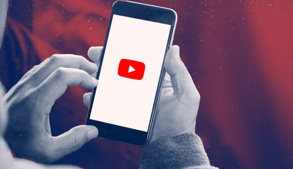 Is YouTube social media image, hands holding a smartphone with red YouTube logo on it.