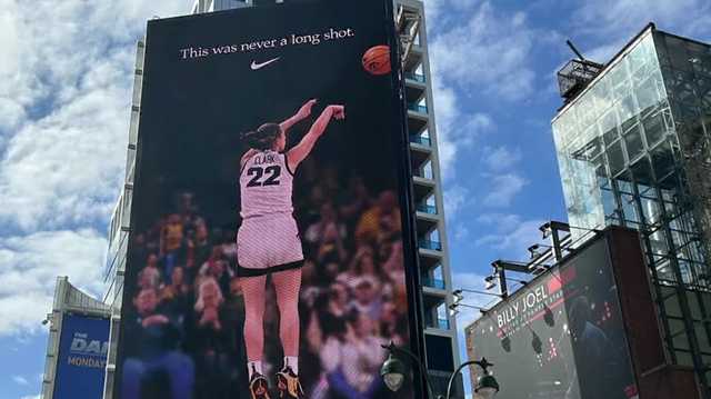 A billboard in Times Square of basketball player Caitlin Clark shooting the ball.