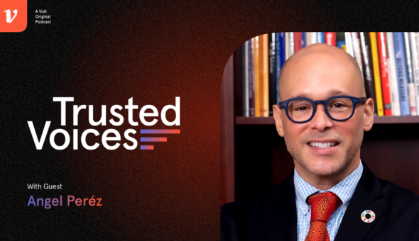 A picture of Angel B. Pérez, the CEO of NACAC. A bald man with dark eyeglasses, a blue suit, blue shirt and red tie.