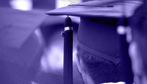 A picture taken from behind a man in a commencement cap and gown with tassel