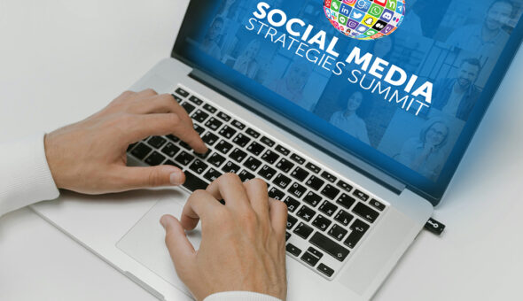 A close-up image of hands typing on a laptop with the words "Social Media Strategies Summit" on the blue background screen.