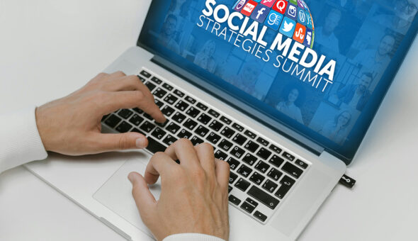 A close-up image of hands typing on a laptop with the words "Social Media Strategies Summit" on the blue background screen.