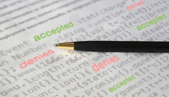 College admissions try to balance innovation, ethics and equity article image. A close-up of a black and gold pen resting on a printed sheet of code. The words 'accepted' in green and 'denied' in red are overlaid on the text, symbolizing decision-making processes in AI-driven admissions.